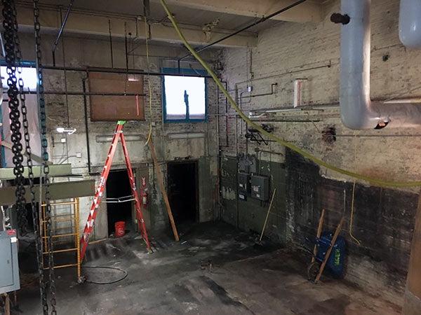 a concrete block room with a concret floor and a ladder