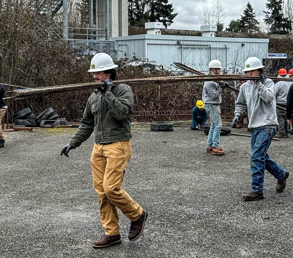 student carrying construction materials