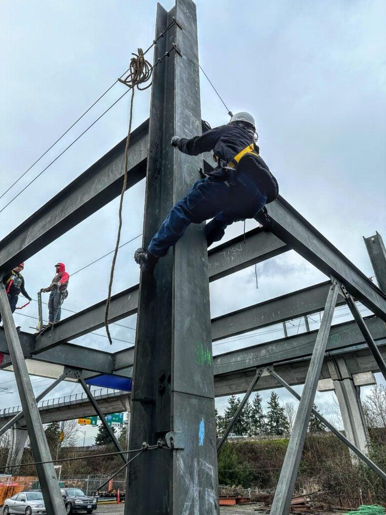 Image of student climbing building during pre-apprenticeship for iron work